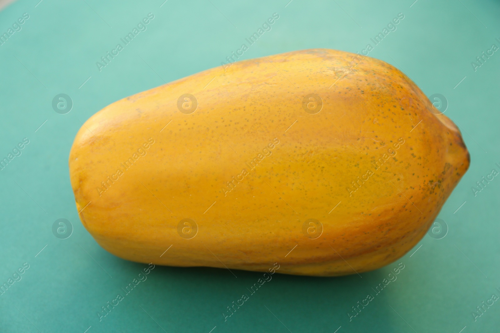 Photo of Fresh ripe whole papaya fruit on light blue background