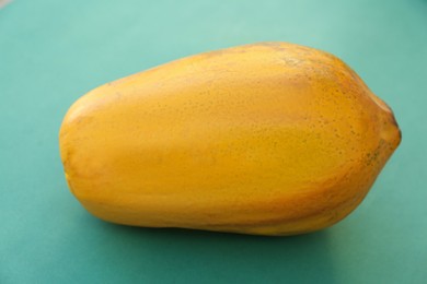 Fresh ripe whole papaya fruit on light blue background