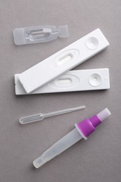 Photo of Disposable express test kits on grey background, flat lay
