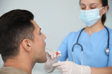 Photo of Doctor taking sample for DNA test from man in clinic