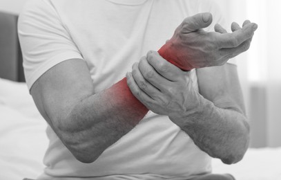 Man suffering from pain in arm, closeup. Black and white effect