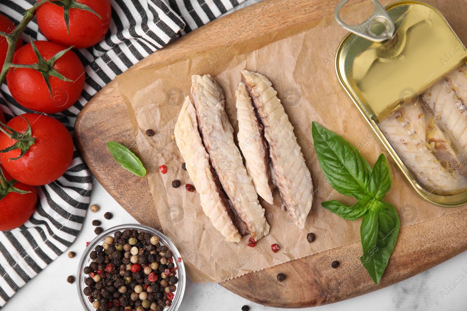 Photo of Canned mackerel fillets served on white marble table, flat lay