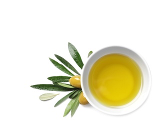 Little bowl with oil, ripe olives and leaves on white background