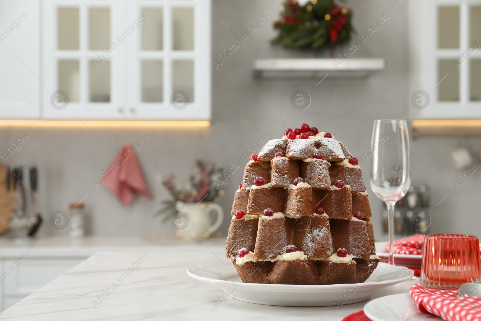Photo of Delicious Pandoro Christmas tree cake decorated with powdered sugar and berries on white marble table. Space for text