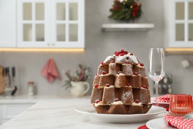 Photo of Delicious Pandoro Christmas tree cake decorated with powdered sugar and berries on white marble table. Space for text