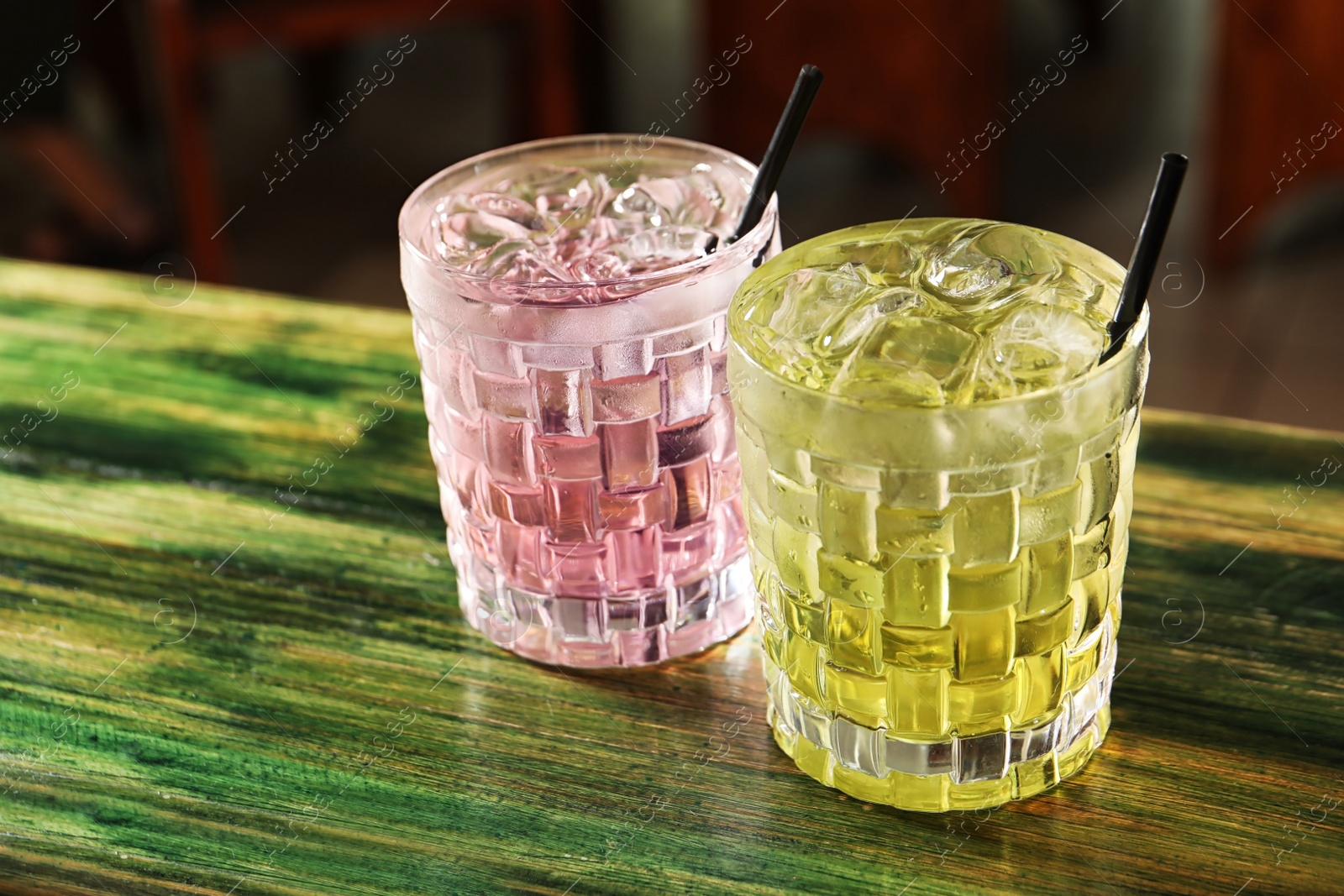 Photo of Glasses of delicious cocktails with ice on table