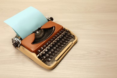 Photo of Vintage typewriter with sheet of paper on wooden table, space for text