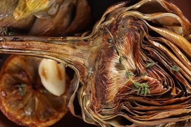 Photo of Tasty grilled artichoke on plate, closeup view