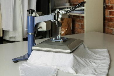 Photo of Printing logo. Heat press with t-shirt on white table, space for text