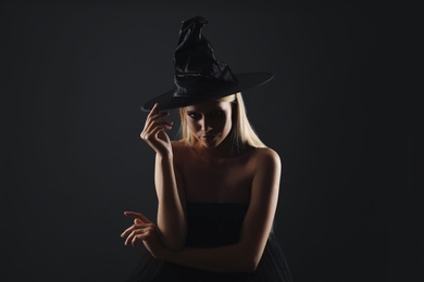 Witch in black hat on dark background. Scary fantasy character