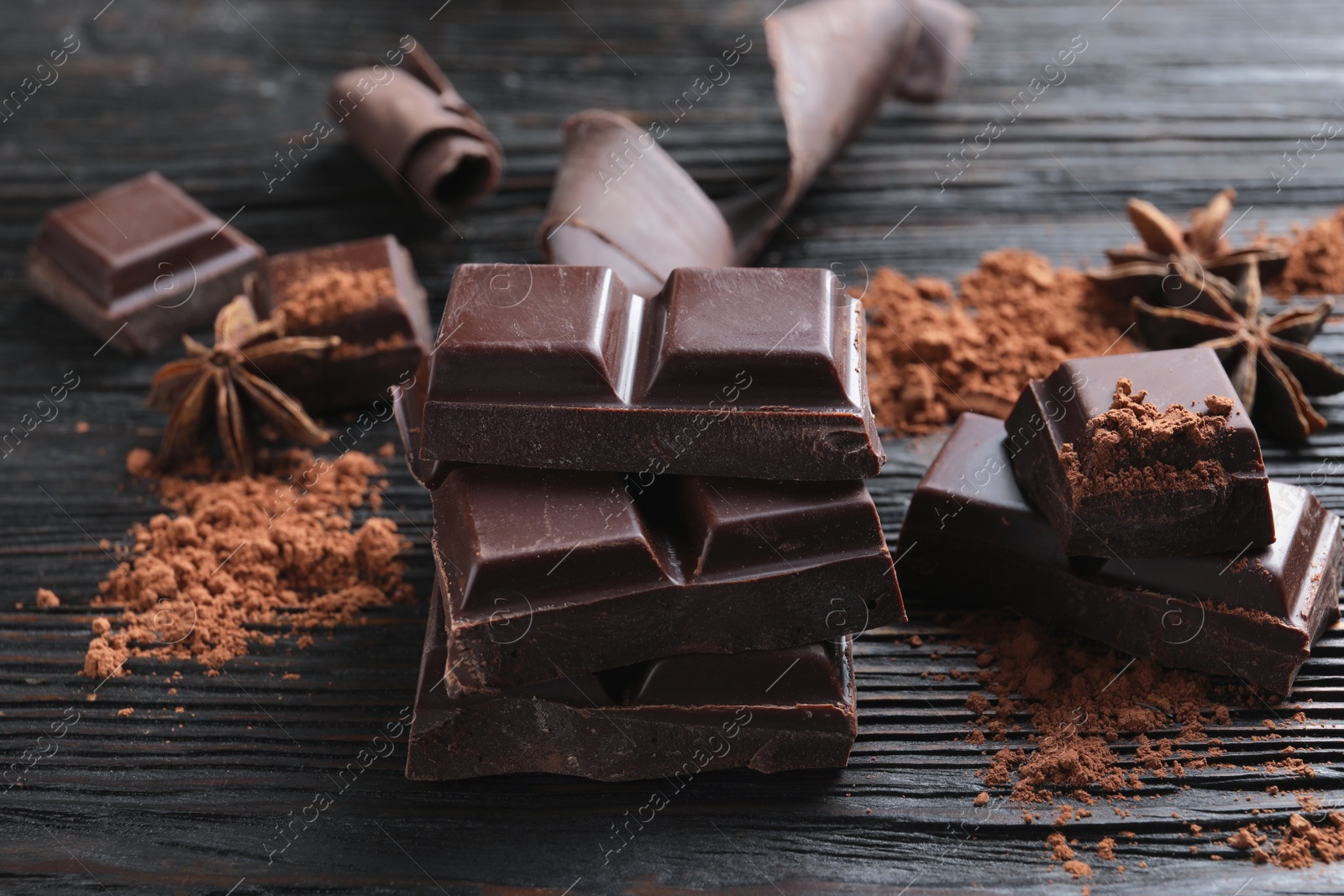 Photo of Pieces of black chocolate on wooden table