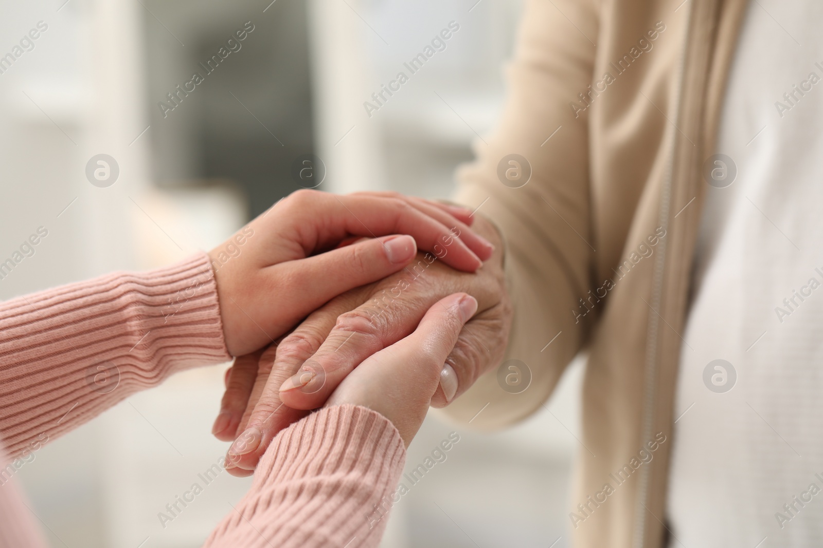 Photo of Trust and support. Woman with her dad joining hands indoors, closeup