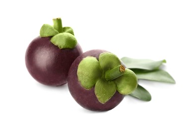 Photo of Delicious ripe mangosteens and green leaves on white background