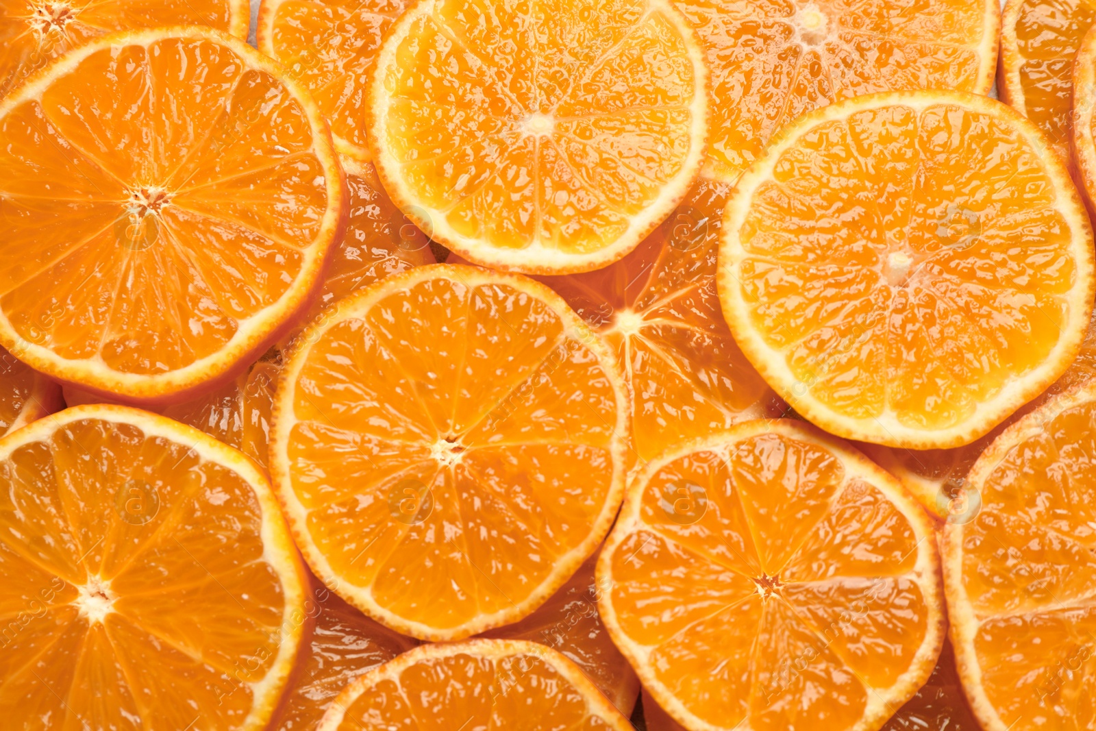 Photo of Slices of fresh ripe tangerines as background, top view. Citrus fruit