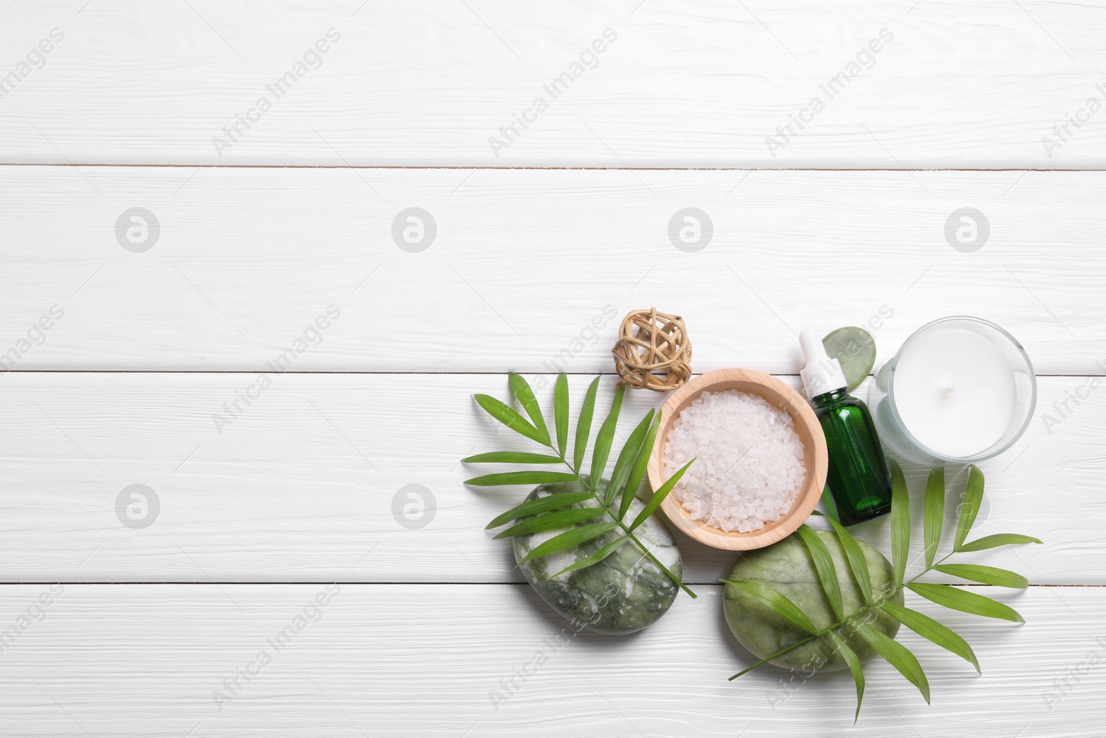 Photo of Flat lay composition with candle and different spa products on white wooden table. Space for text