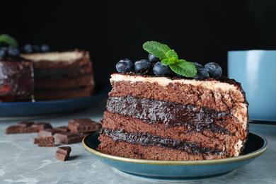 Photo of Tasty chocolate cake with berries on grey marble table