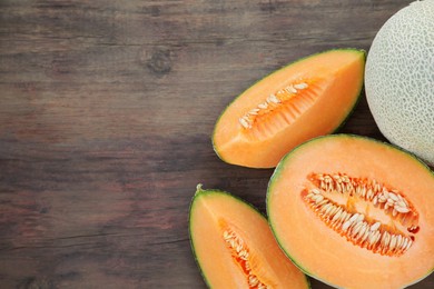 Photo of Tasty orange ripe melons on wooden table, flat lay. Space for text