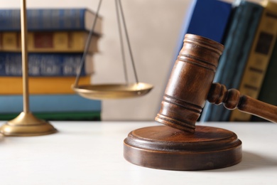 Photo of Wooden gavel, scales of justice and books on table. Law concept