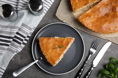 Photo of Delicious pie with meat and basil on grey table, flat lay