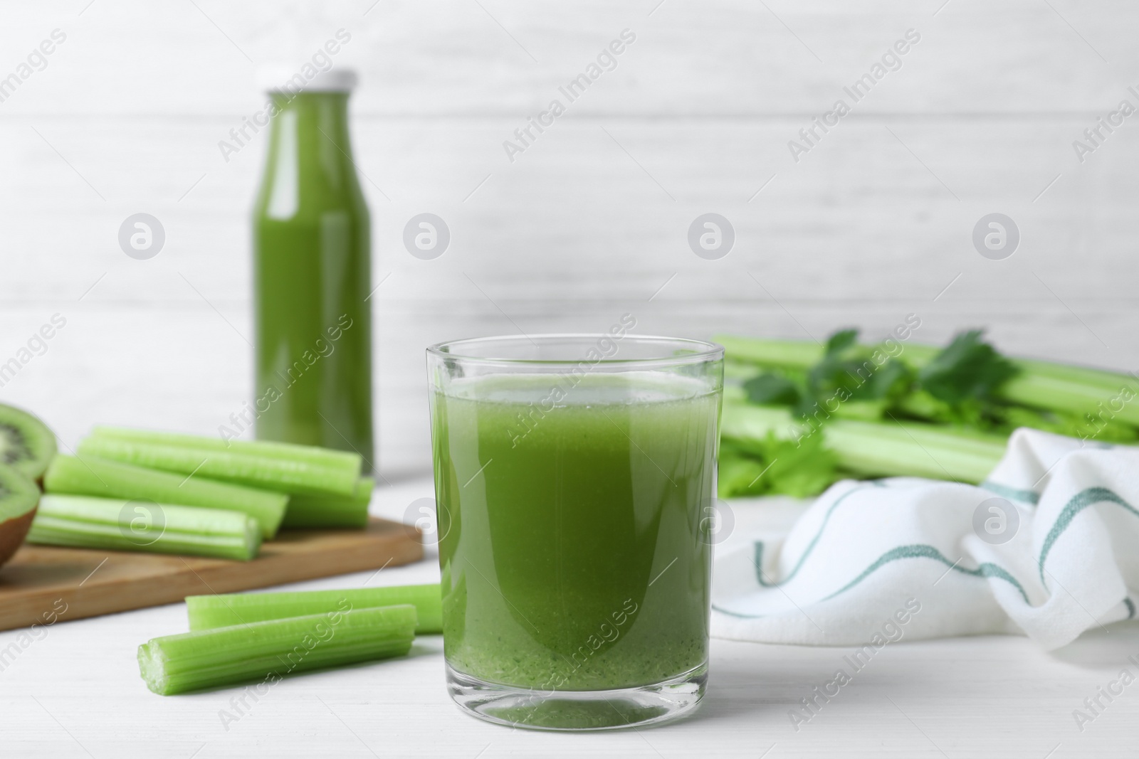 Photo of Glass of fresh celery juice on white wooden table