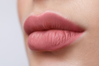 Photo of Young woman with beautiful lips on light grey background, closeup view