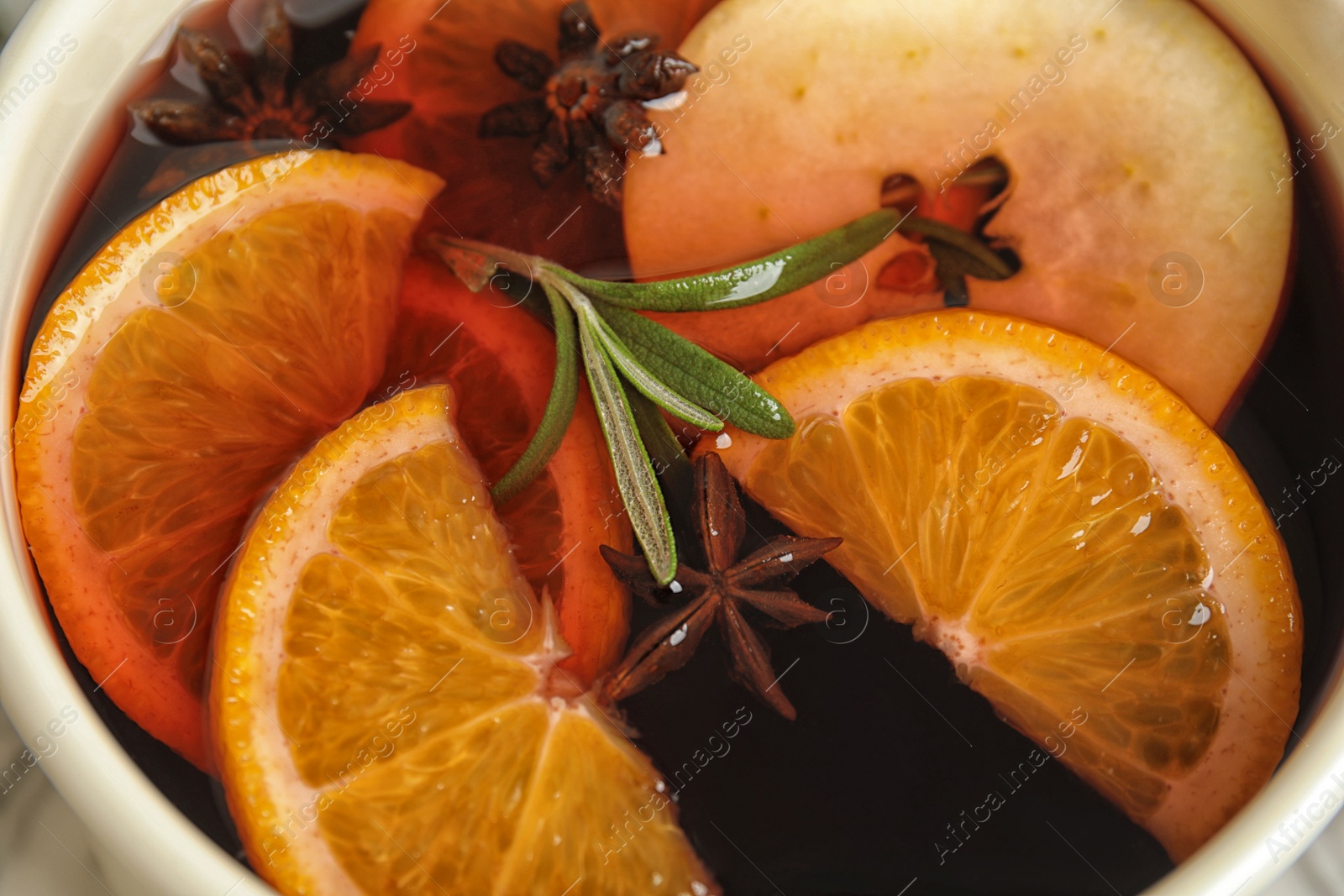 Photo of Tasty mulled wine with spices in cooking pot, closeup