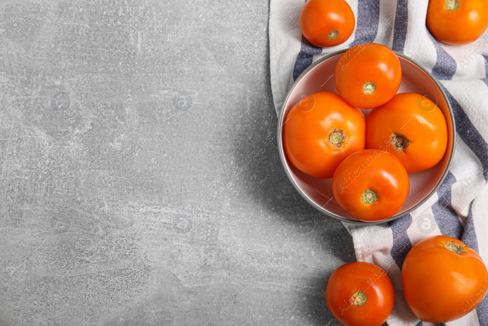 Photo of Many ripe yellow tomatoes on grey table, flat lay. Space for text