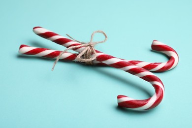 Photo of Two sweet Christmas candy canes with bow on turquoise background
