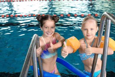 Photo of Cute little girls in indoor swimming pool