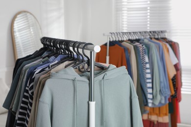 Racks with stylish clothes indoors. Fast fashion