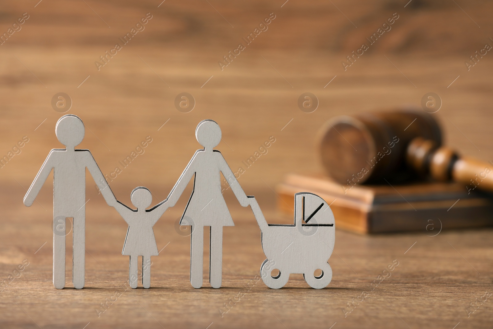 Photo of Family law. Figure of parents with children and gavel on wooden table, space for text