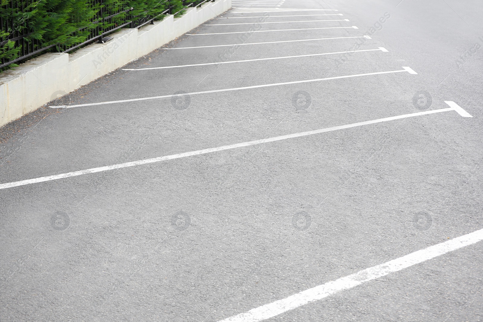 Photo of Empty outdoor parking lot with painted markings on asphalt