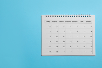 Photo of Paper calendar on light blue background, top view. Space for text