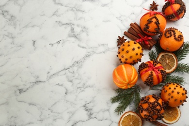 Photo of Flat lay composition with pomander balls made of fresh tangerines and cloves on white marble table, space for text