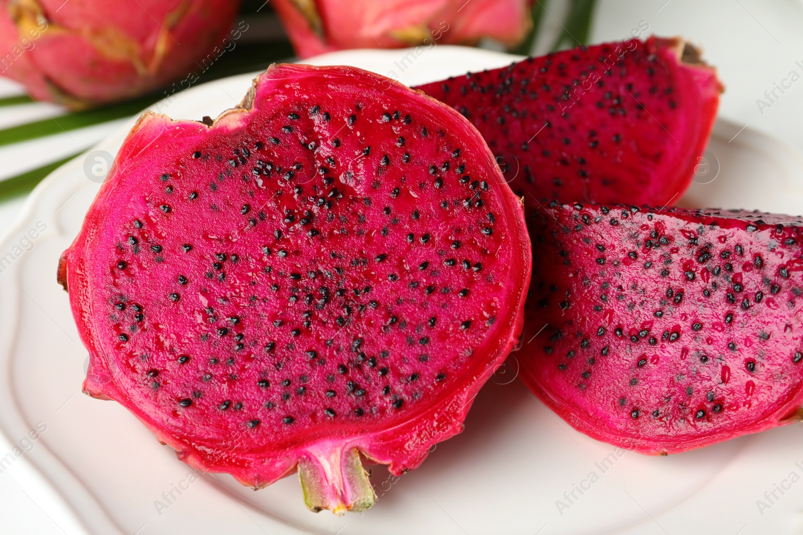 Photo of Plate of delicious cut red pitahaya fruit, closeup