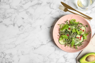 Salad with fresh organic microgreen in bowl on white marble table, flat lay. Space for text