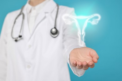Doctor and illustration of female reproductive system on light blue background, closeup