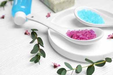 Photo of Spoons with sea salt on table. Spa cosmetics