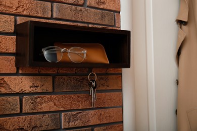 Photo of Stylish hanger for keys on brick wall in hallway