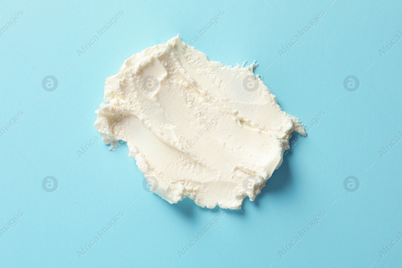 Photo of Smear of tasty cream cheese on color background, top view