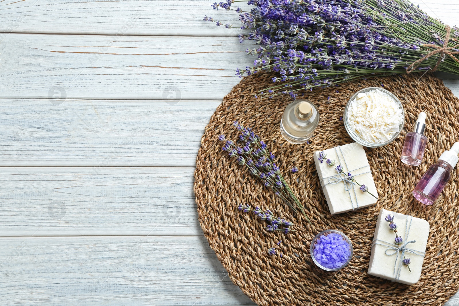 Photo of Flat lay composition of handmade soap bars with lavender flowers on white wooden background. Space for text