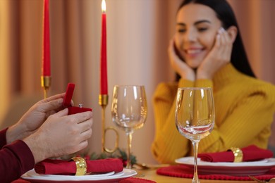 Man with engagement ring making proposal to his girlfriend at home on Christmas, selective focus