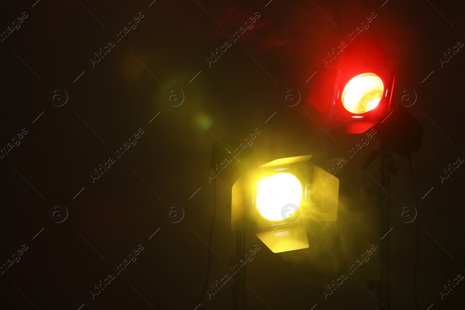 Photo of Bright colorful spotlights in darkness, space for text