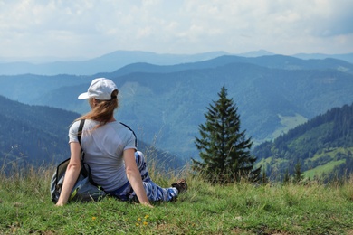 Woman with backpack in wilderness. Mountain landscape