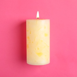 Alight scented wax candle on color background