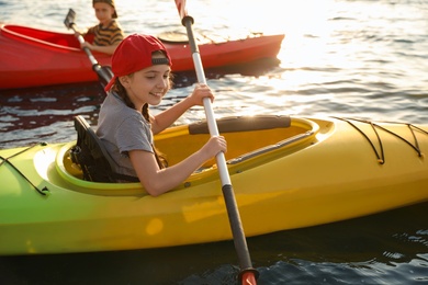 Little children kayaking on river. Summer camp activity