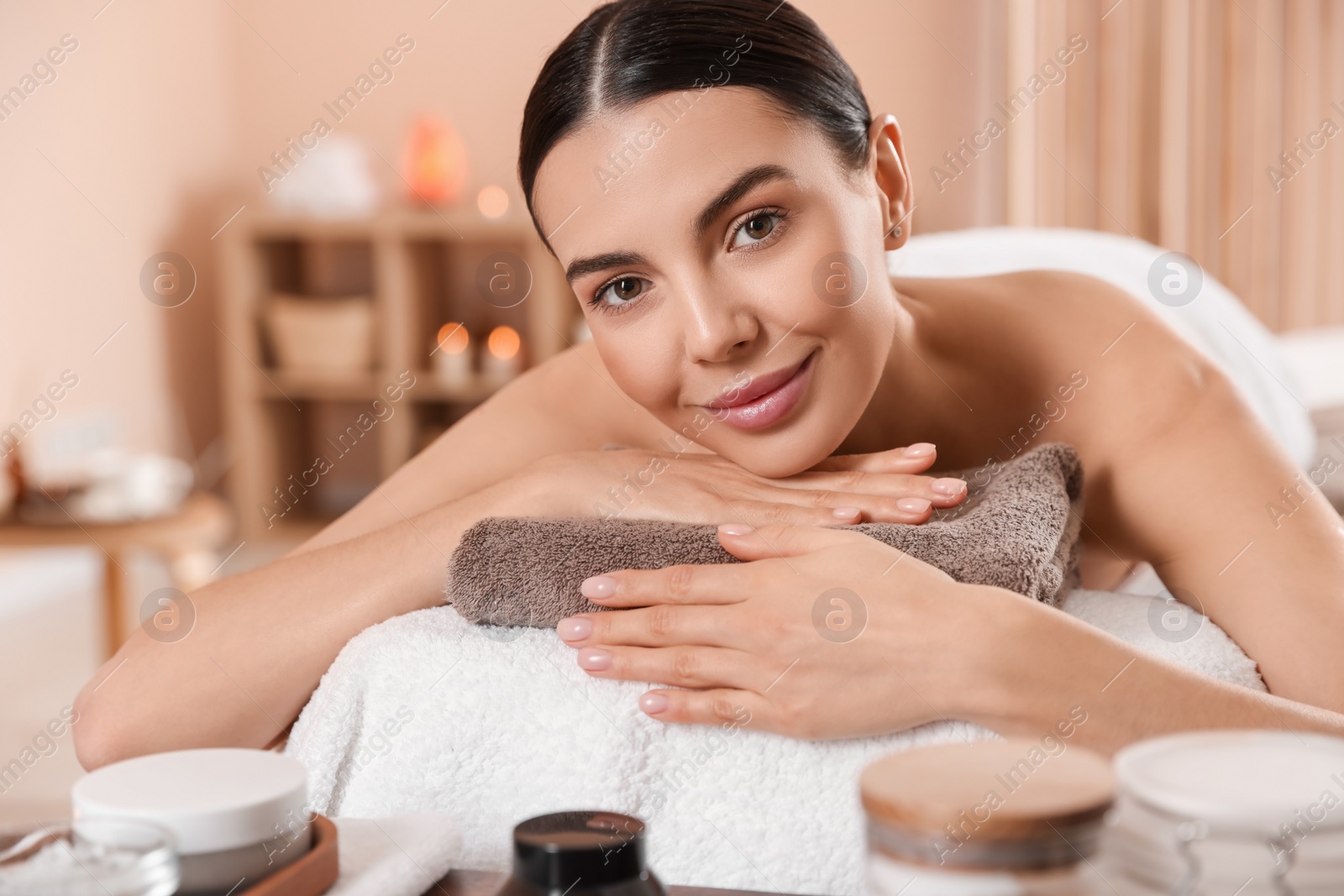 Photo of Young woman resting on massage couch in spa salon