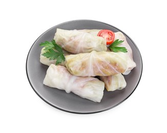 Photo of Plate with Uncooked stuffed cabbage rolls, tomato and parsley isolated on white