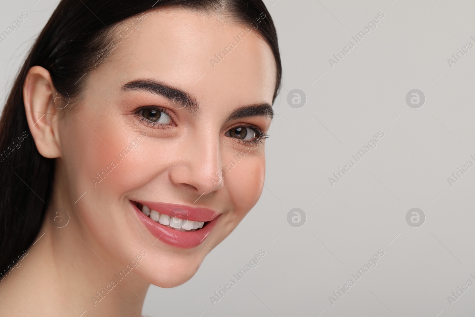 Photo of Beautiful woman with healthy skin on gray background, closeup. Space for text