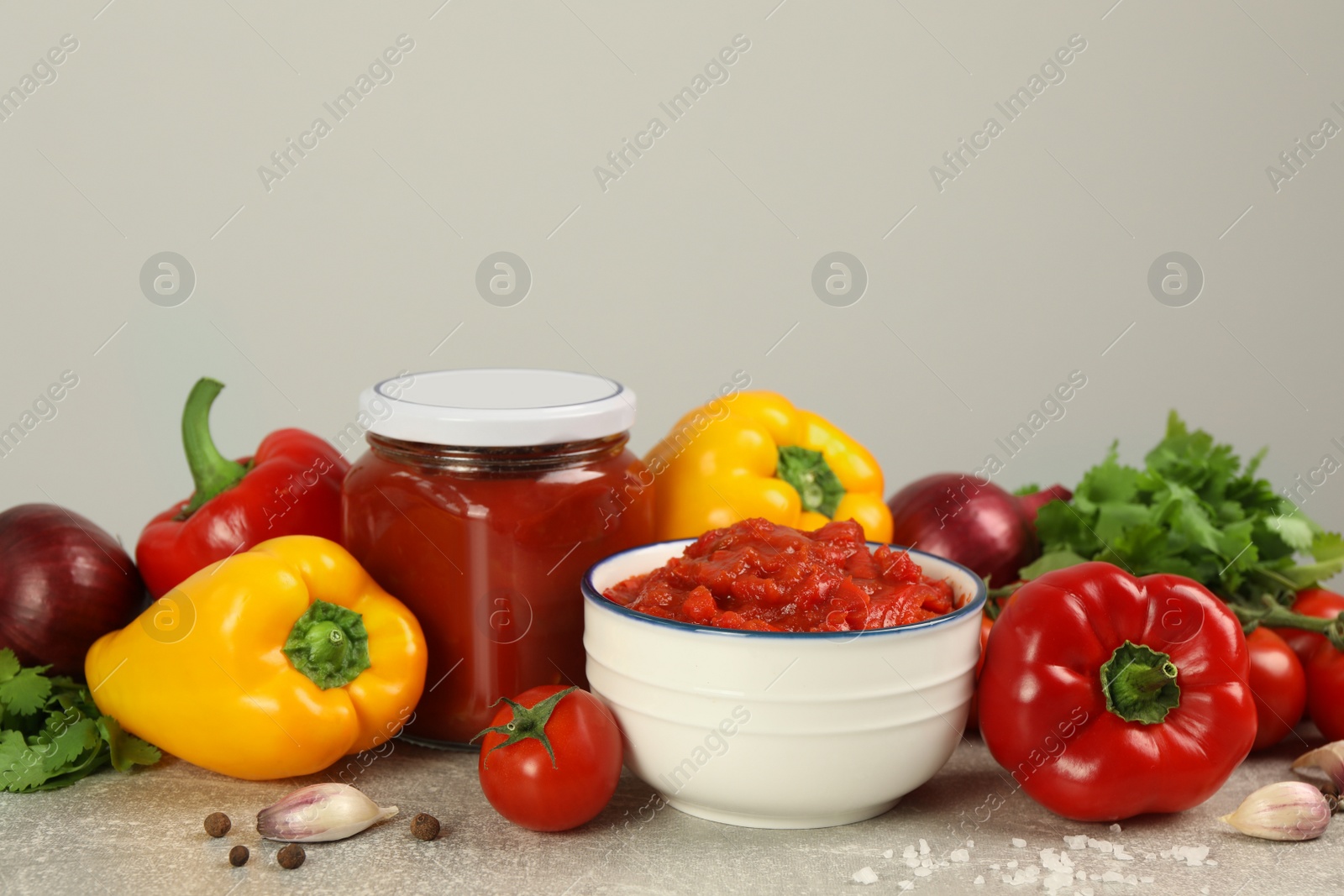 Photo of Delicious lecho and fresh ingredients on light grey table